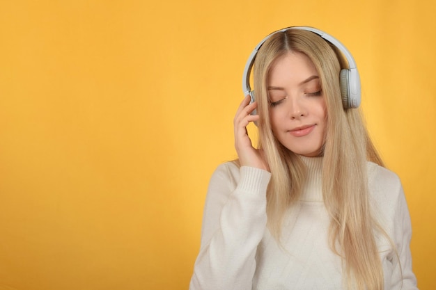 Una donna con le cuffie su uno sfondo giallo