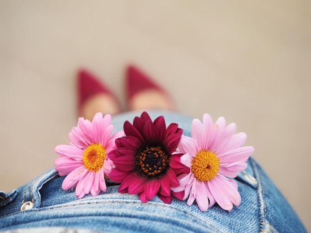 Una donna con le scarpe rosa tiene dei fiori in tasca