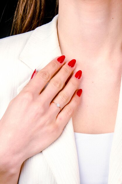 una donna con le unghie rosse e un anello al dito