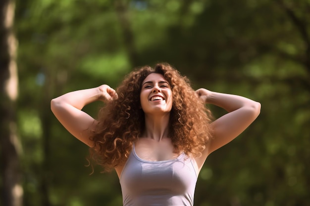 Una donna con lunghi capelli ricci sorride e alza le braccia davanti a uno sfondo verde.