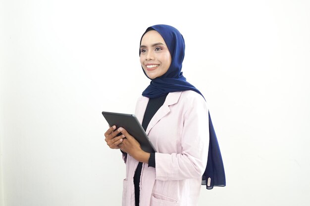 Una donna con un abito rosa e una sciarpa blu tiene in mano un tablet