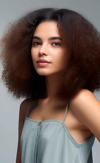 Una donna con un'acconciatura afro naturale si trova su uno sfondo bianco.