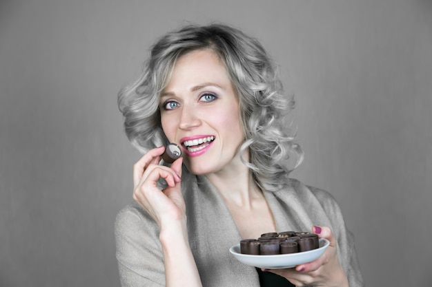 Una donna con un bel sorriso sta mangiando caramelle.