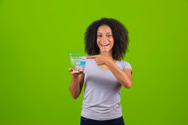 Una donna con un bicchiere d'acqua davanti a uno sfondo verde.