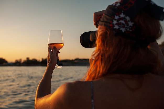 Una donna con un bicchiere di vino davanti a un lago