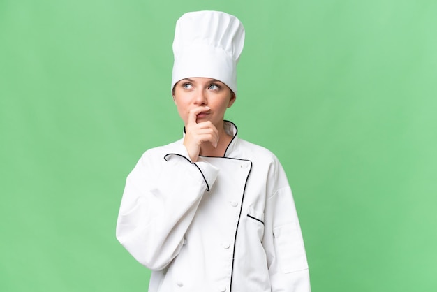 Una donna con un cappello da chef si trova davanti a uno schermo verde.