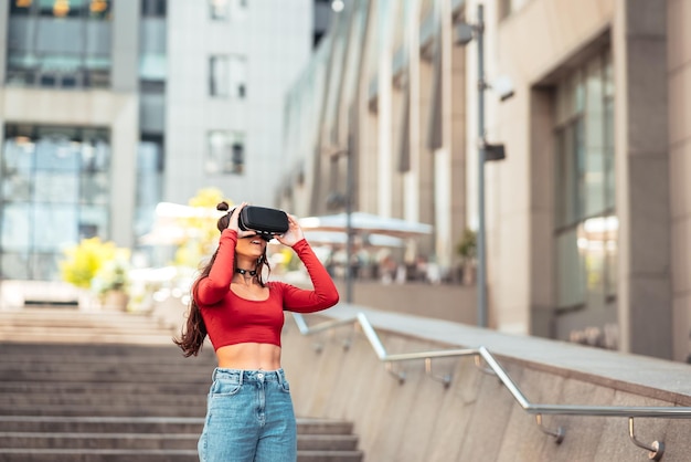Una donna con un casco per realtà virtuale cammina per strada