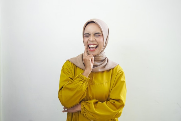 Una donna con un hijab giallo sta ridendo e indossa un hijab giallo.