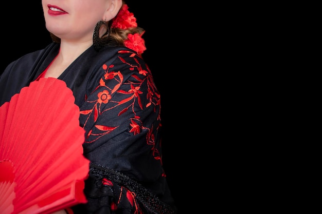 Una donna con un kimono rosso e nero tiene in mano un ventaglio.