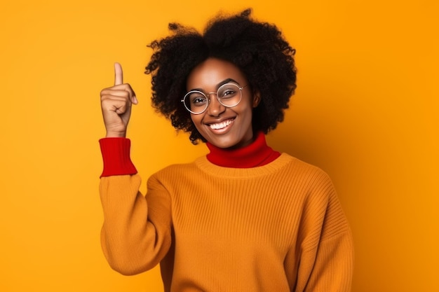 Una donna con un maglione giallo e gli occhiali punta il dito indice verso l'alto.