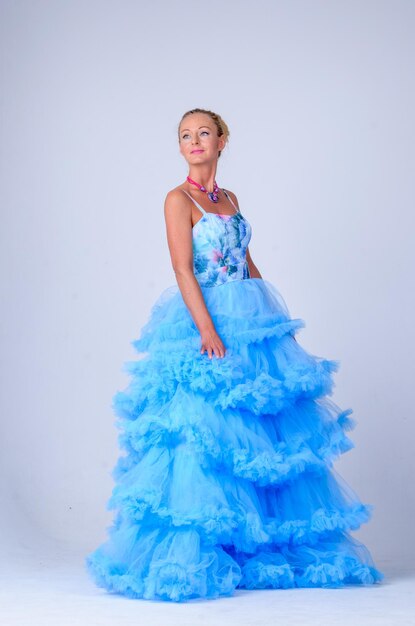 Una donna con un vestito da sera blu posa per la telecamera