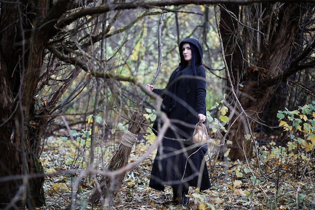 Una donna con un vestito da strega in una foresta