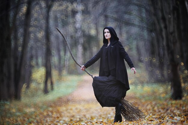 Una donna con un vestito da strega in una foresta