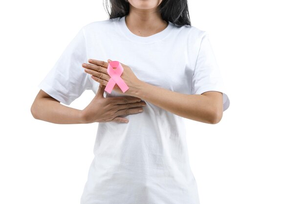 Una donna con una camicia bianca mostra un nastro rosa di consapevolezza