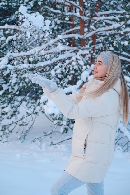 Una donna con una giacca bianca che lancia la neve in aria