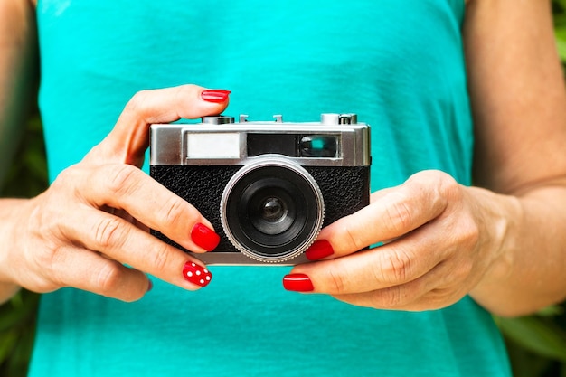 Una donna con una macchina fotografica con un disegno a pois rossi sul davanti.