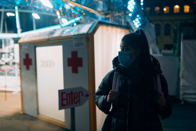 Una donna con una maschera medica sta soggiornando nel tunnel di disinfezione