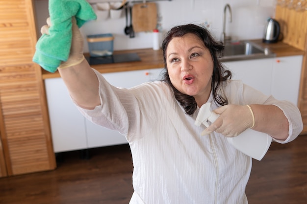 Una donna con uno straccio pulisce e lava in cucina