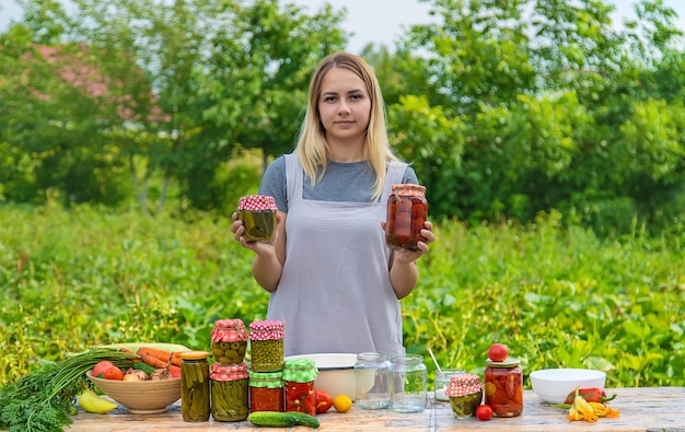 Una donna conserva le verdure in vasetti Messa a fuoco selettiva