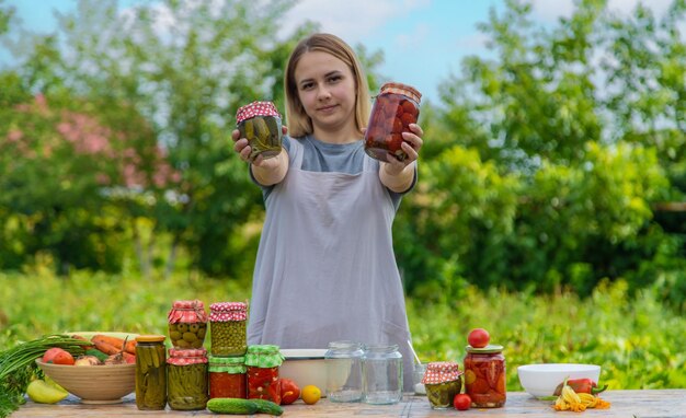 Una donna conserva le verdure in vasetti Messa a fuoco selettiva