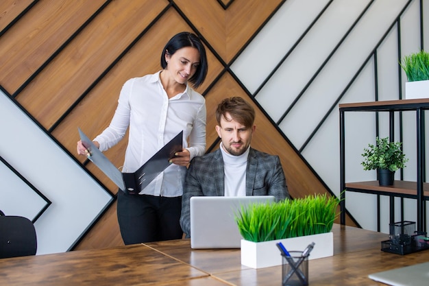 Una donna controlla il lavoro dei dipendenti in ufficio