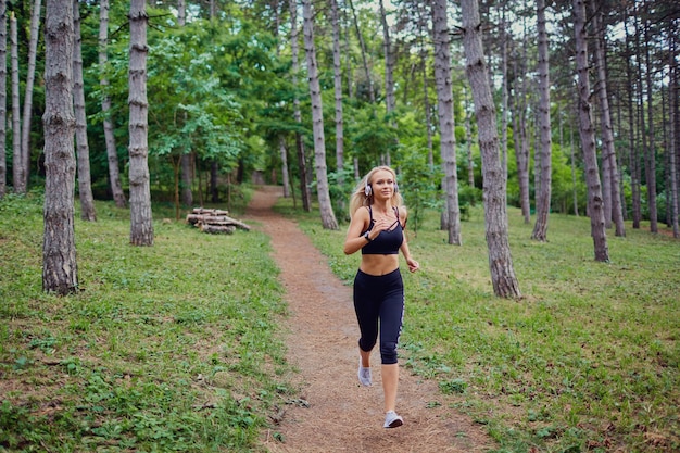 Una donna corre a fare jogging nella foresta.