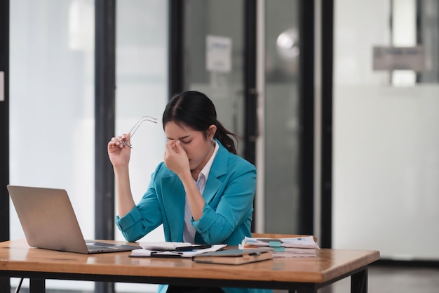 Una donna d'affari asiatica stressata a causa di un lavoro eccessivo e di una scadenza
