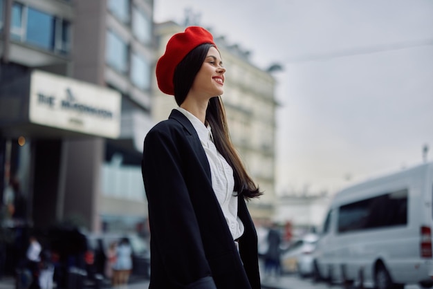 Una donna d'affari cammina in città sullo sfondo di edifici per uffici eleganti vestiti alla moda e viaggi di trucco primaverile