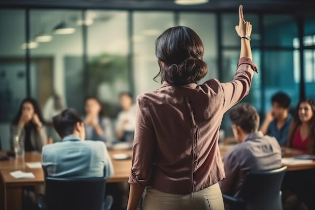 una donna d'affari casuale che alza il braccio in una riunione di conferenza che simboleggia l'impegno e la proattività