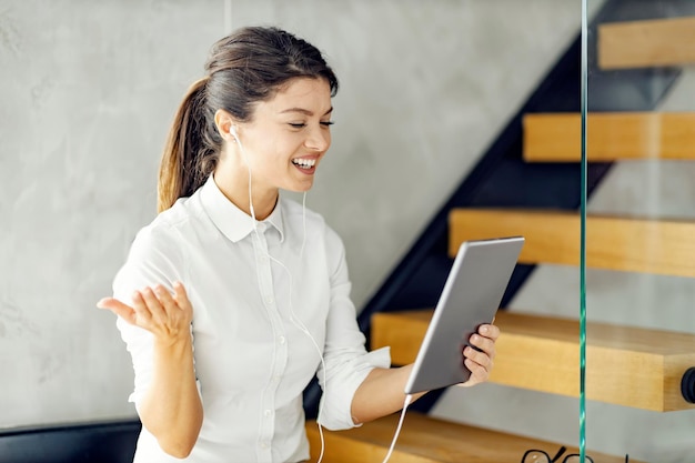 Una donna d'affari che ha una teleconferenza in ufficio su tablet