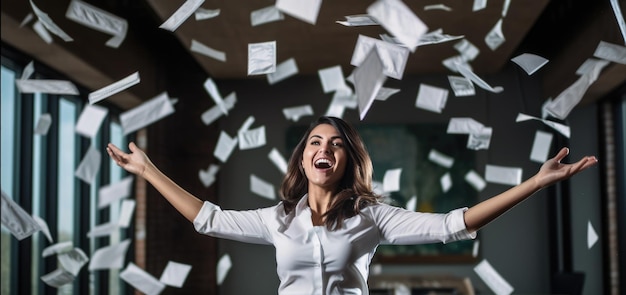 Una donna d'affari felice che lancia documenti in aria come segno di vittoria e successo nel suo lavoro