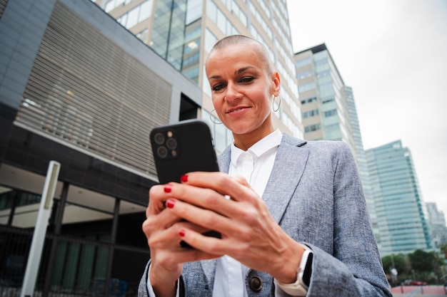 Una donna d'affari sicura che usa un cellulare per lavorare in un posto di lavoro del centro.