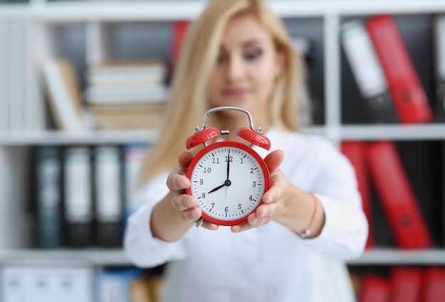 Una donna d'affari sorridente con un orologio in mano