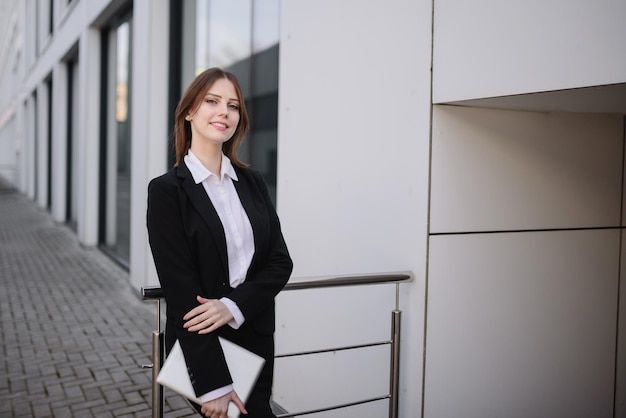 Una donna d'affari sorridente tiene in mano una tavoletta