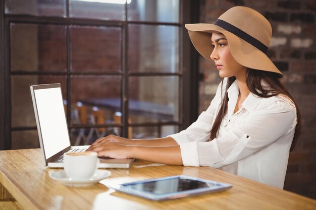 Una donna d&#39;affari usando il suo computer portatile mentre vi godete un caffè