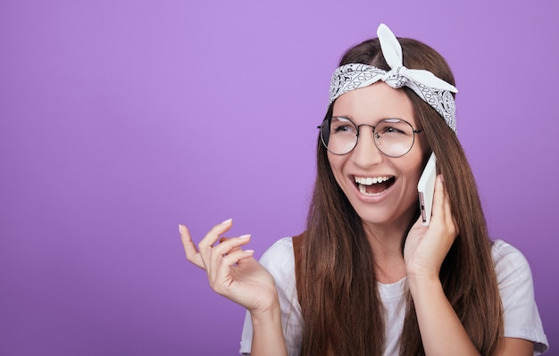 Una donna dai capelli castani che ride parla al telefono