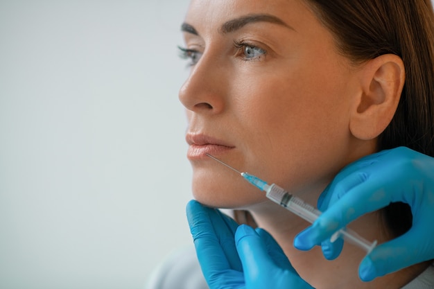 Una donna dai capelli scuri che ha procedure di trattamento di bellezza alla cometologia