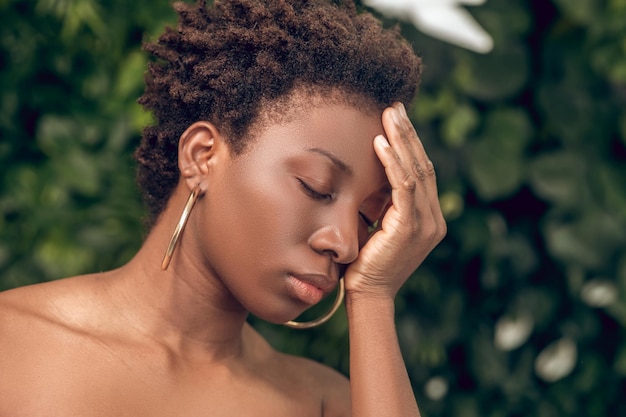 Una donna dalla pelle scura che soffre di mal di testa