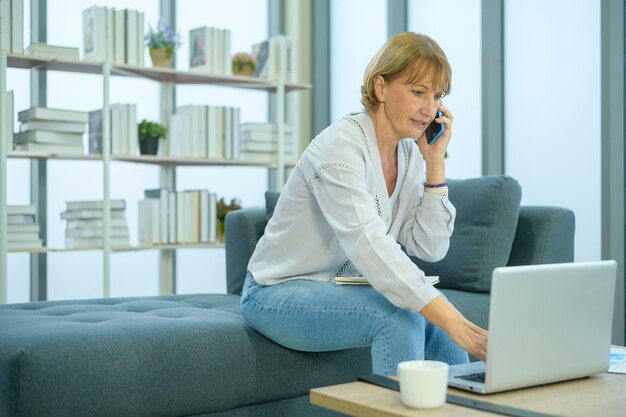 Una donna di affari anziana caucasica che lavora nell'ufficio moderno