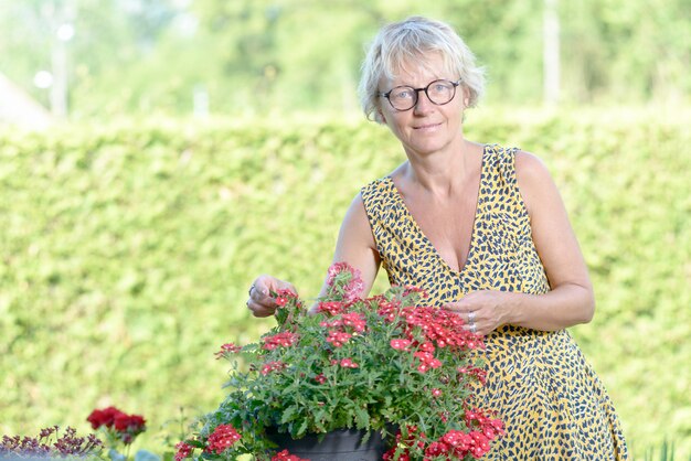 Una donna di mezza età che si prende cura dei fiori