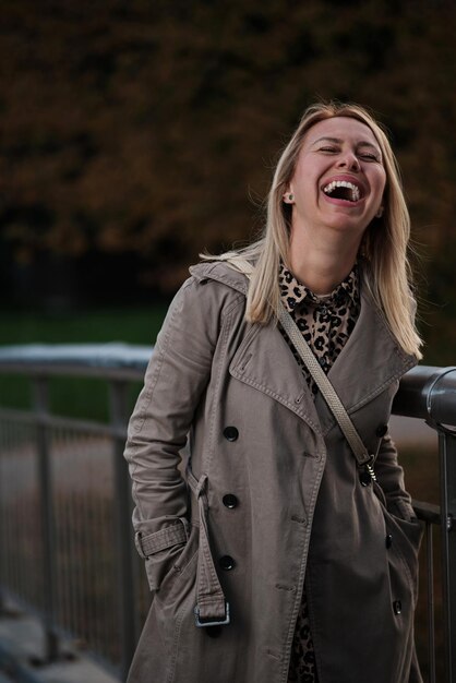 Una donna di mezza età elegante e felice che ride sorridendo fuori