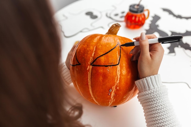 Una donna dipinge una zucca ad Halloween