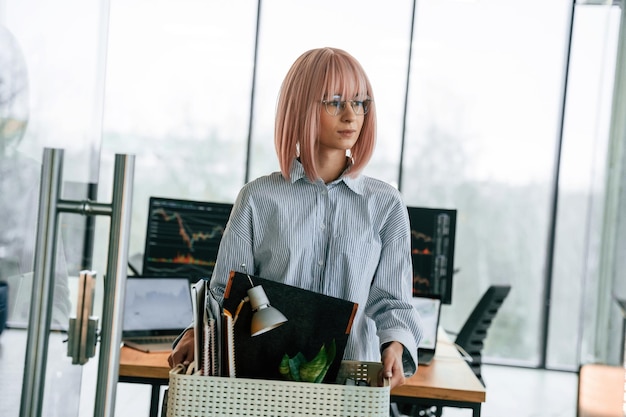 Una donna disoccupata con i capelli rosa e' con gli oggetti personali dopo essere stata licenziata.