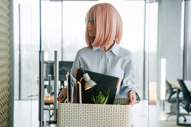 Una donna disoccupata con i capelli rosa e' con gli oggetti personali dopo essere stata licenziata.