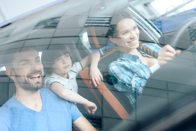 Una donna è seduta al volante di una nuova auto.