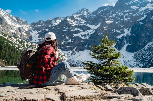 Una donna è seduta sulla riva di un lago Morskie Oko Tatra