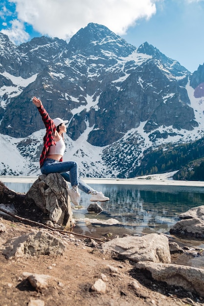 Una donna è seduta sulla riva di un lago Morskie Oko Tatra