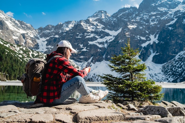 Una donna è seduta sulla riva di un lago Morskie Oko Tatra