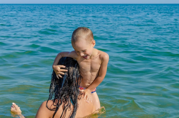 Una donna e suo figlio nuotano in mare in un giorno d'estate.