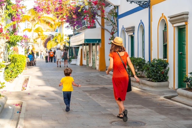 Una donna e un bambino camminano per una strada con un sacco di negozi